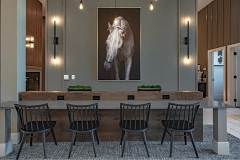 a dining room with a table and chairs and a painting of a horse