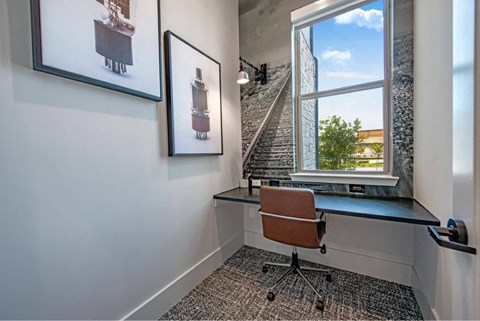 a home office with a window and a desk with a chair