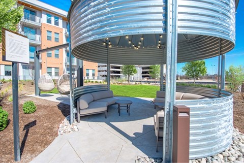 a patio with a couch and a table under a canopy