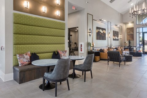 a communal area with tables and chairs in the lobby of a building
