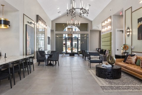 a large lobby with a chandelier and tables and chairs