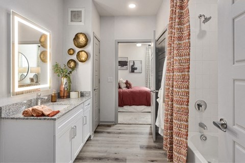 a bathroom with a shower and a sink and a bed