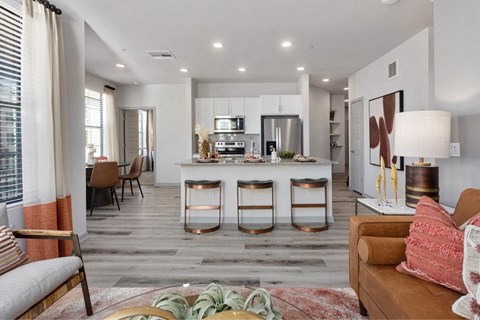 the view of a living room and a kitchen with a table and chairs