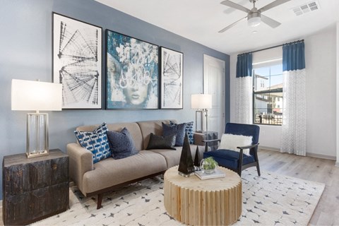 a living room with blue walls and a tan couch