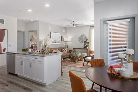 the view of a living room and dining room from a kitchen with a dining table