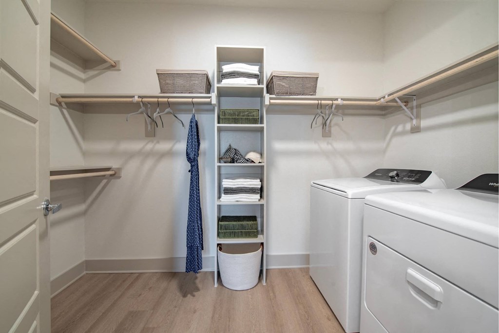 a laundry room with a washer and dryer and shelves