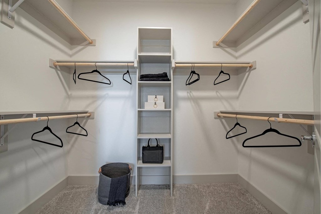 a walk in closet with a ladder and hanging clothes