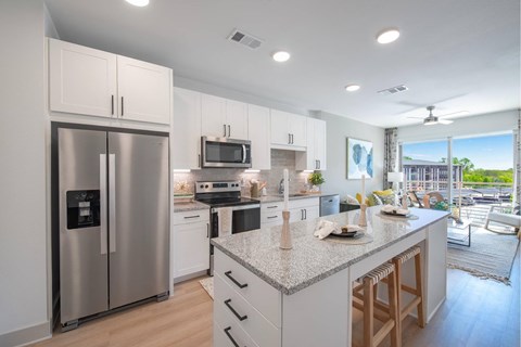 a kitchen with a island and a stainless steel refrigerator