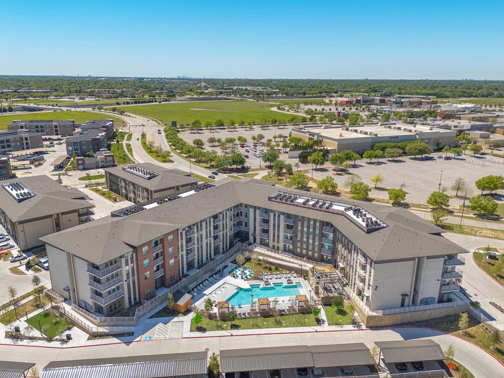 an aerial view of a large building with a swimming pool