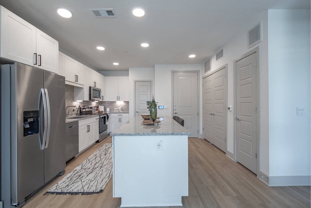 a kitchen with stainless steel appliances and white cabinets