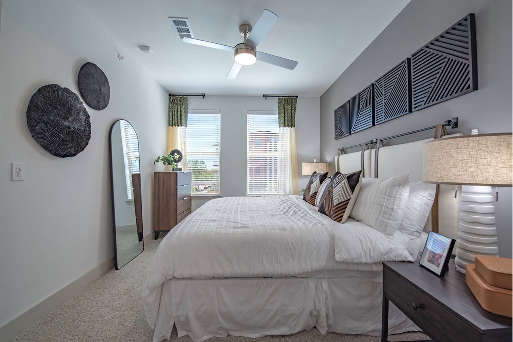 a bedroom with a large bed and a ceiling fan