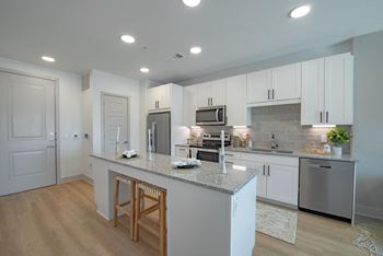 a kitchen with white cabinets and a granite counter top
