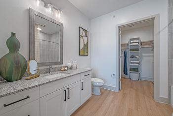 Spacious bathroom(s) with granite countertops, modern tile surrounds, framed mirrors, curved shower rods, rainfall shower heads