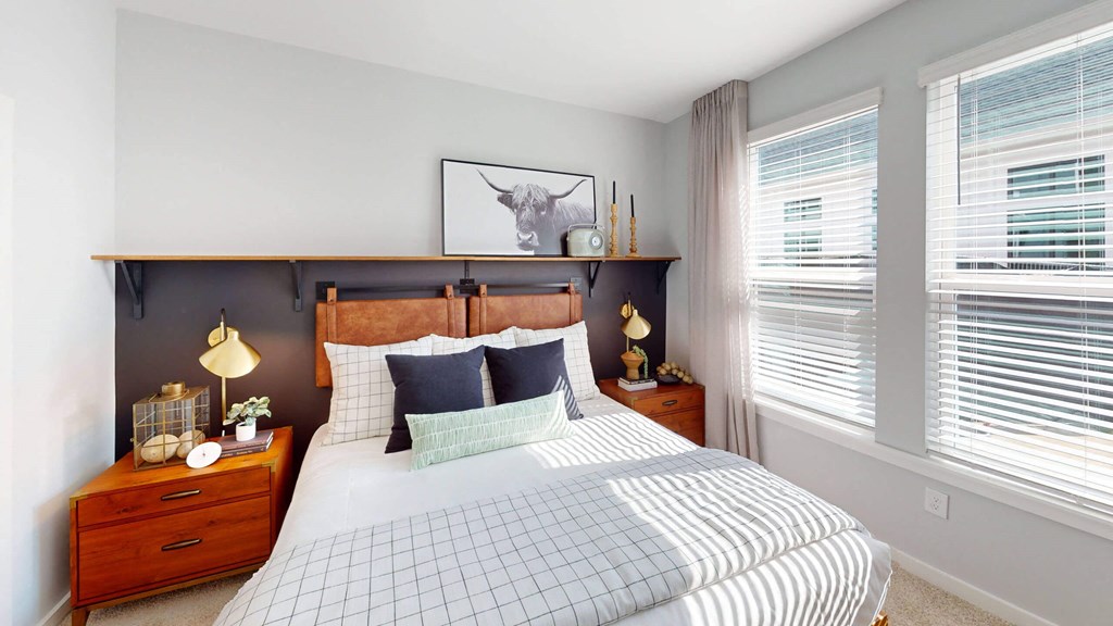 a bedroom with a bed and two windows