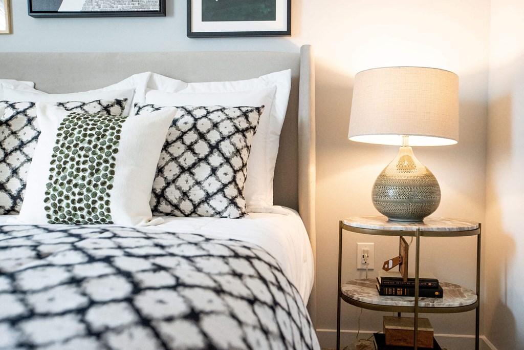 a bedroom with a bed and a nightstand with a lamp