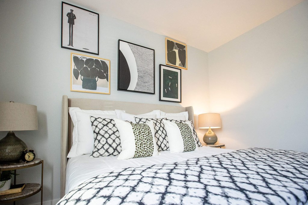 a bedroom with a bed and framed pictures on the wall