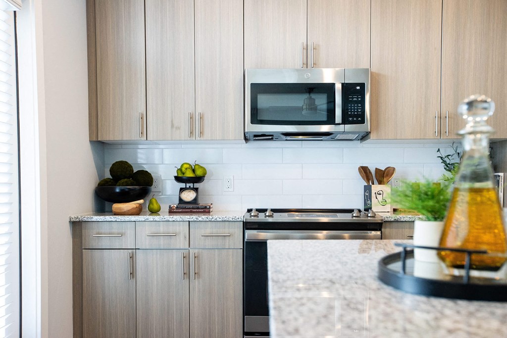 a kitchen with white cabinets and a counter top and a microwave