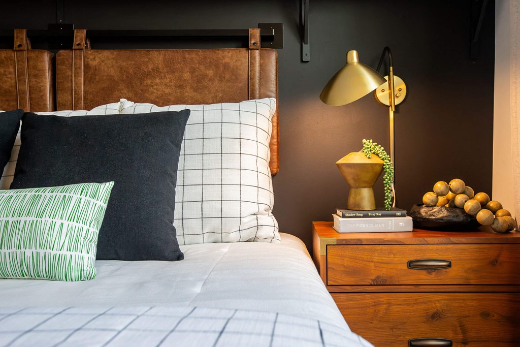 a bedroom with a bed and a nightstand with a lamp and a dresser