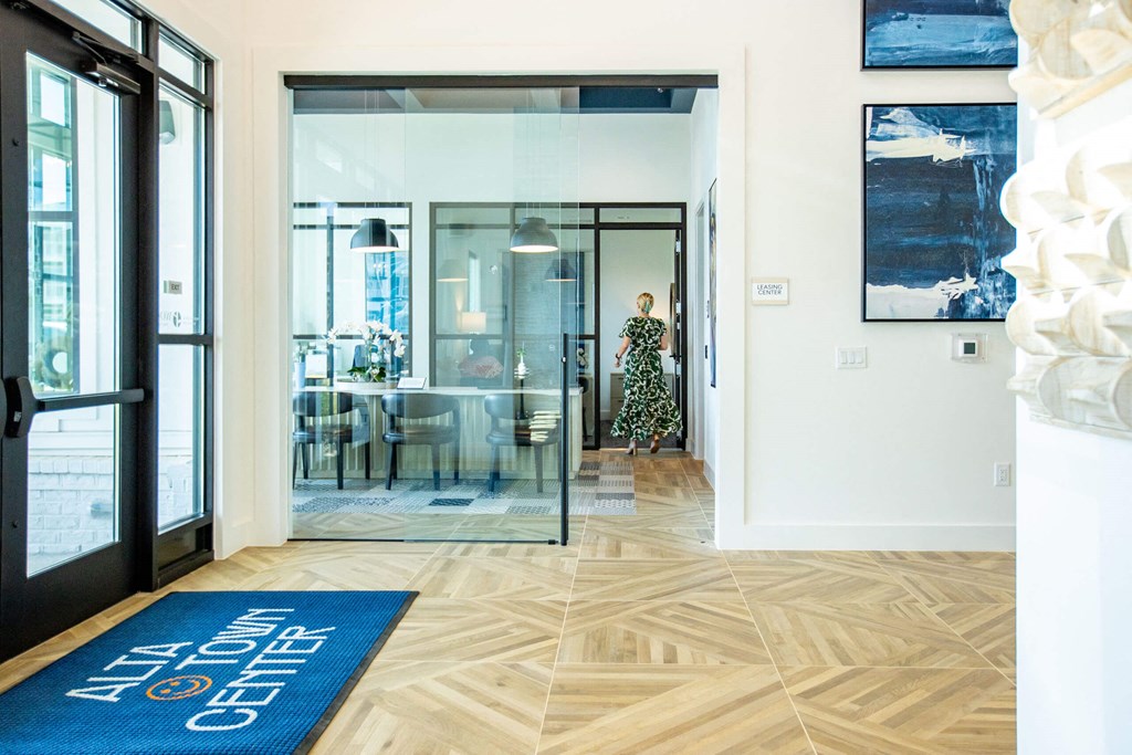a living room with a blue rug and a glass door