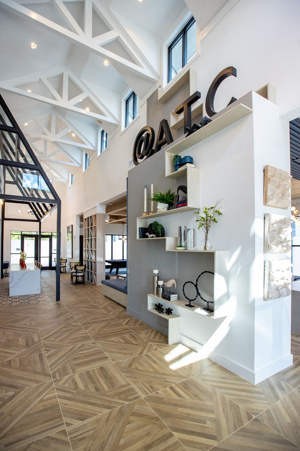 a view of the lobby of a modern house with white walls and wood floors
