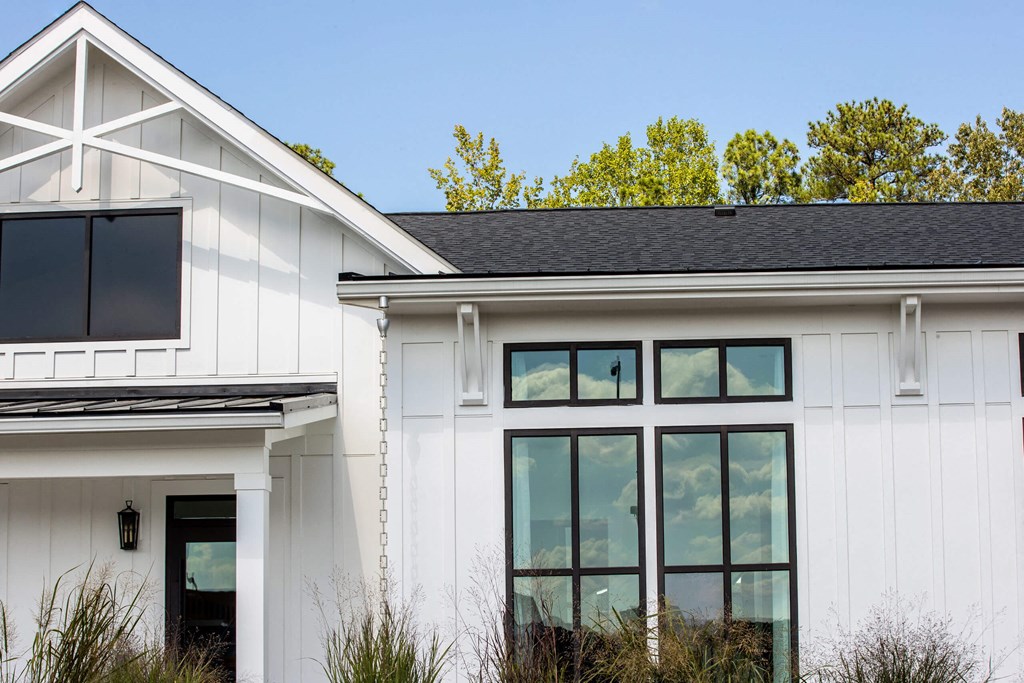 the exterior of a white house with large windows