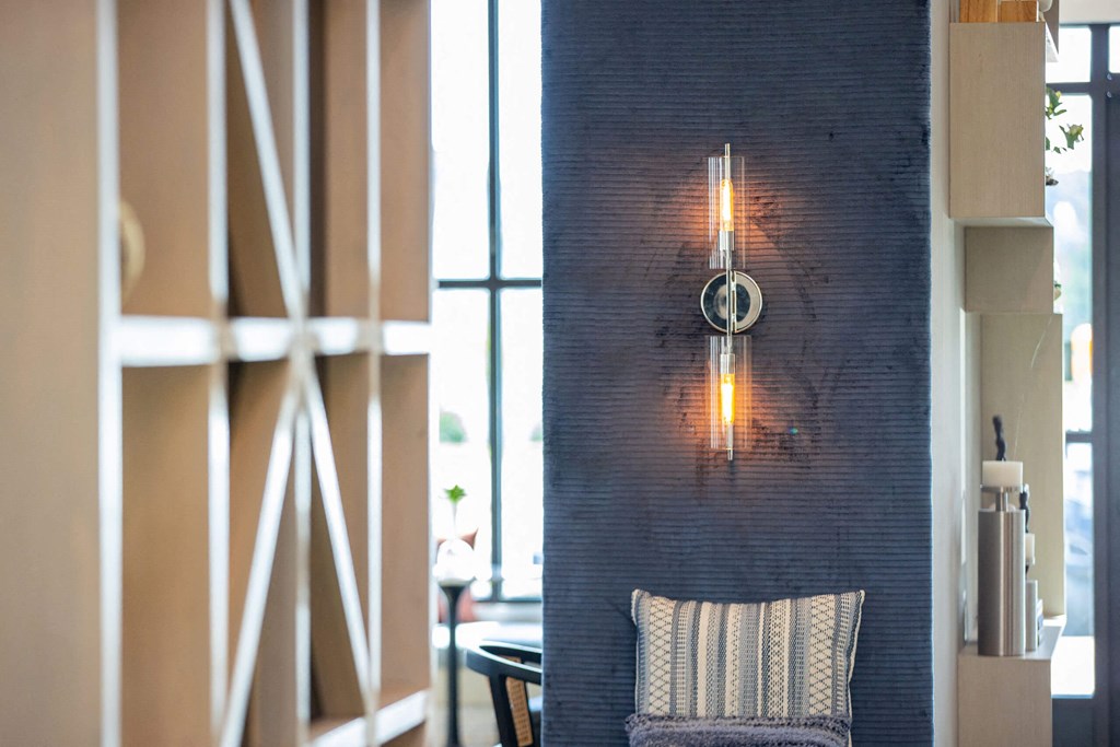 a living room with a couch and a light on a brick wall