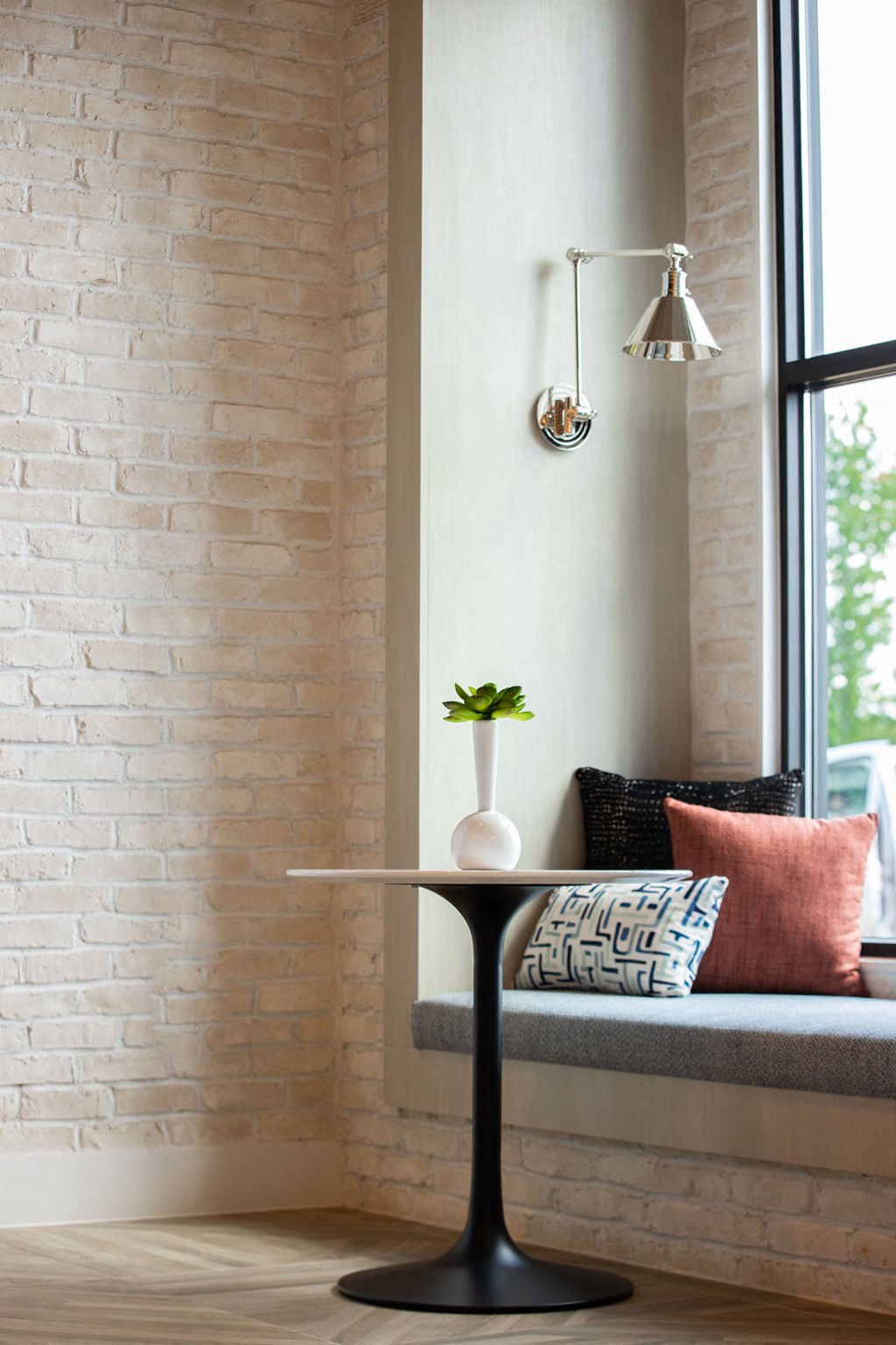 a small table with a vase on it next to a window