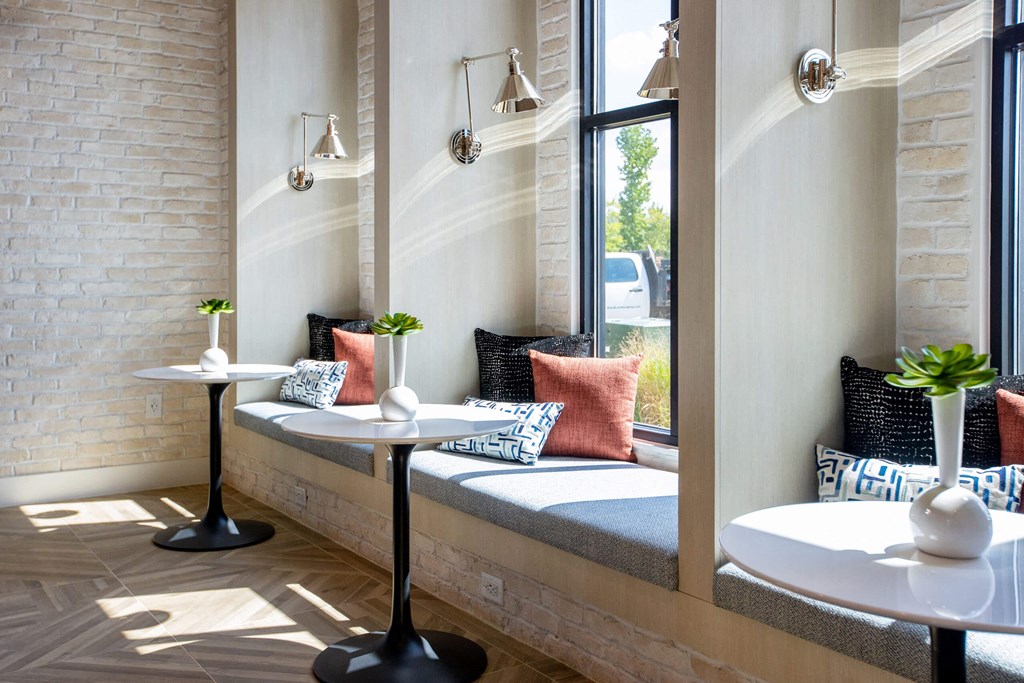 a seating area with two tables and a window