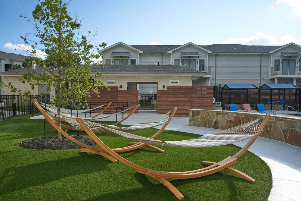 a backyard with hammocks and a tree
