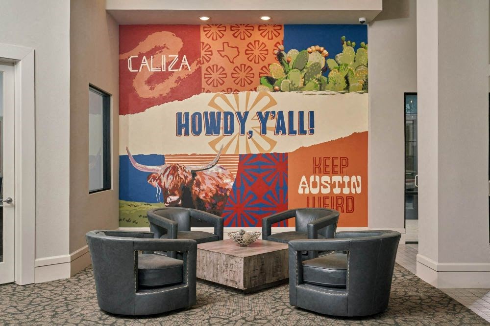 a lobby with chairs and a mural on the wall