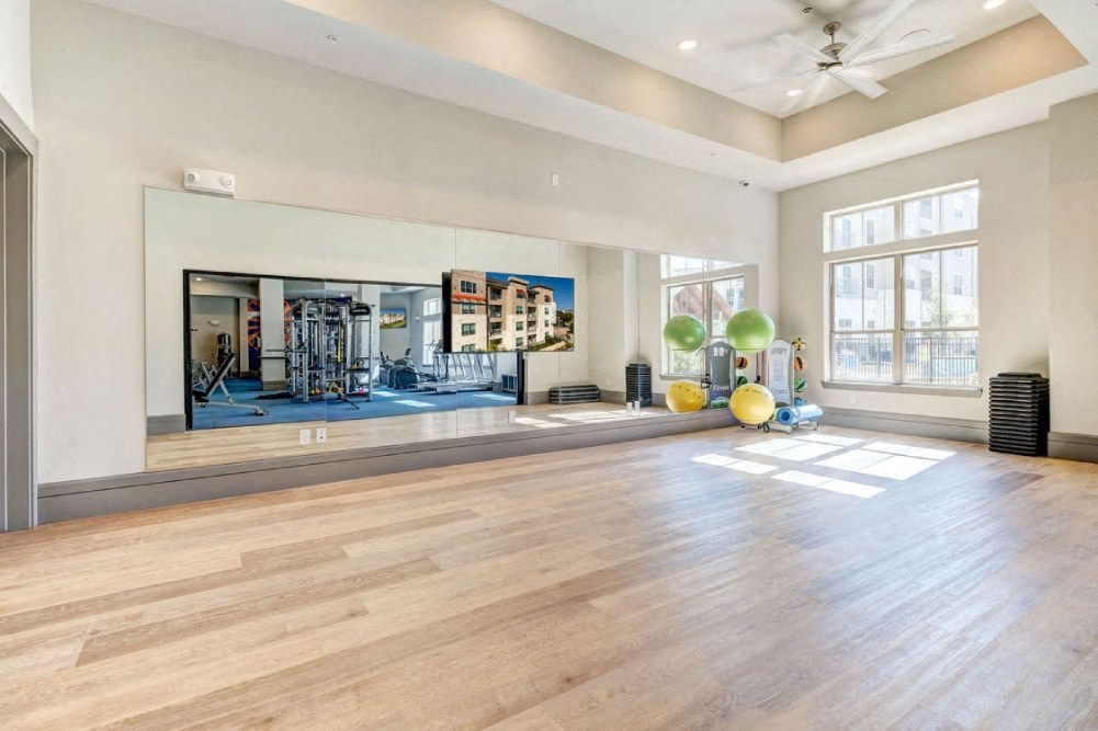 the home has a yoga room with a large window and hardwood floors
