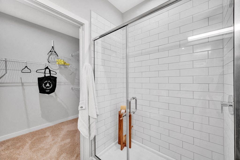 a white bathroom with a shower with a glass door