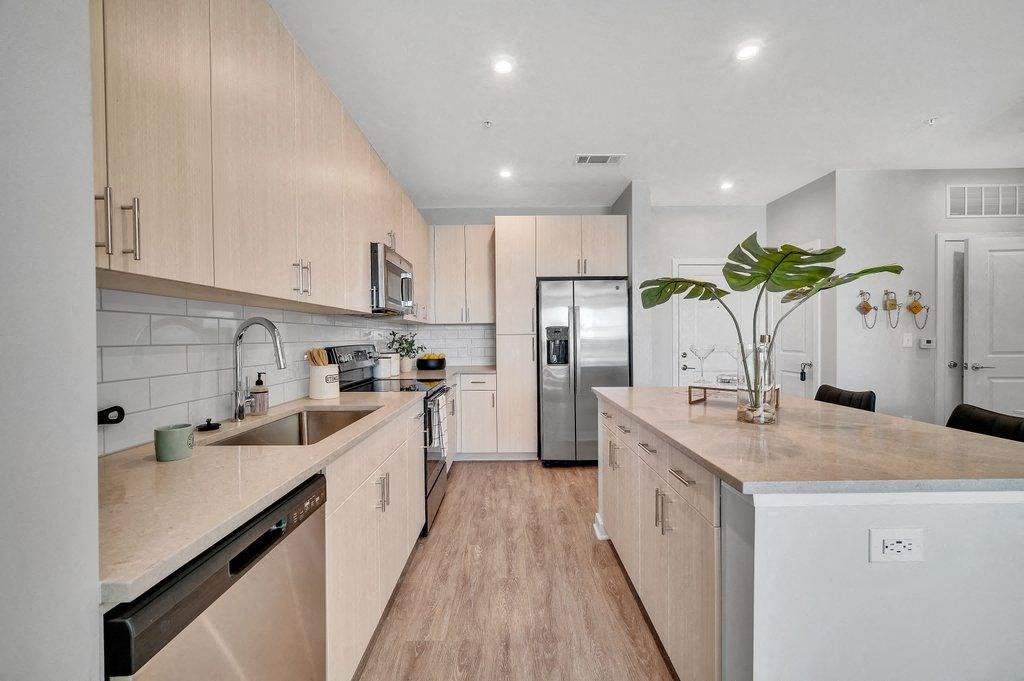 a kitchen with white cabinets and a stainless steel refrigerator