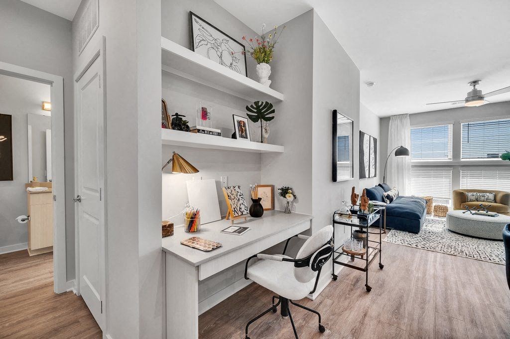 a home office with a desk and a living room