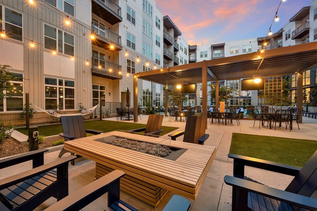 an outdoor patio with tables and chairs at an apartment complex