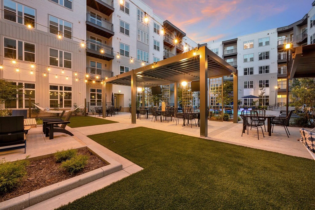 an outdoor patio with tables and chairs at an apartment complex