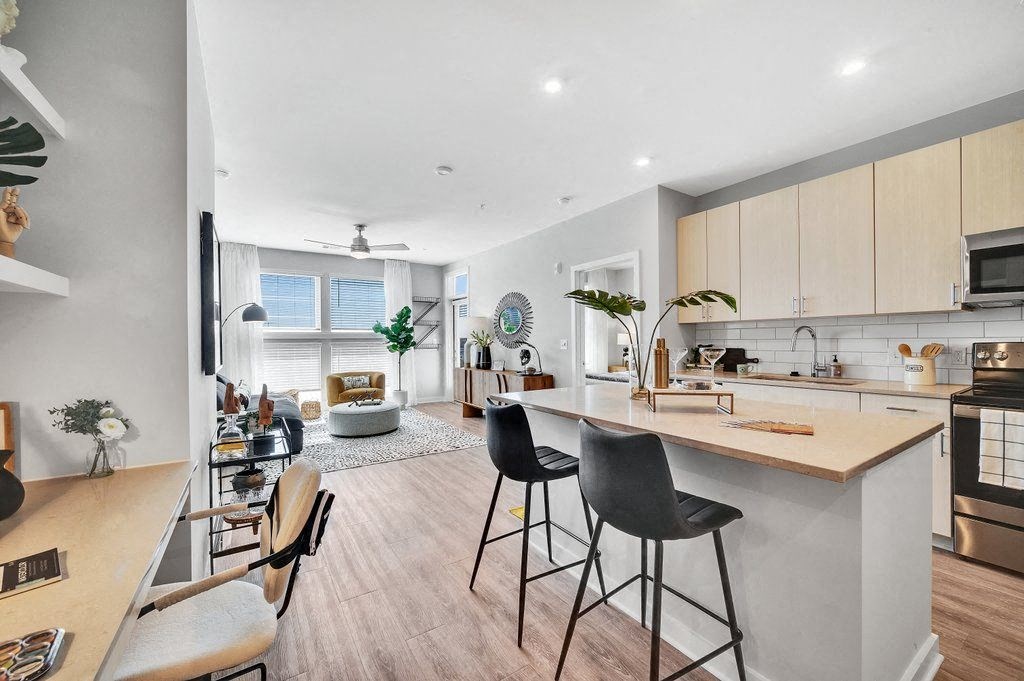 an open kitchen and living room with a bar and stools
