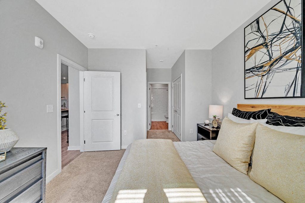 a bedroom with a large bed and a door to a bathroom