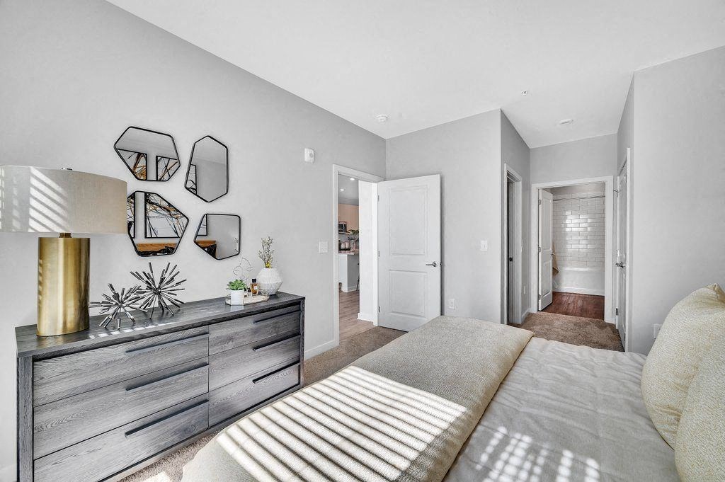 a bedroom with a bed and a dresser in it