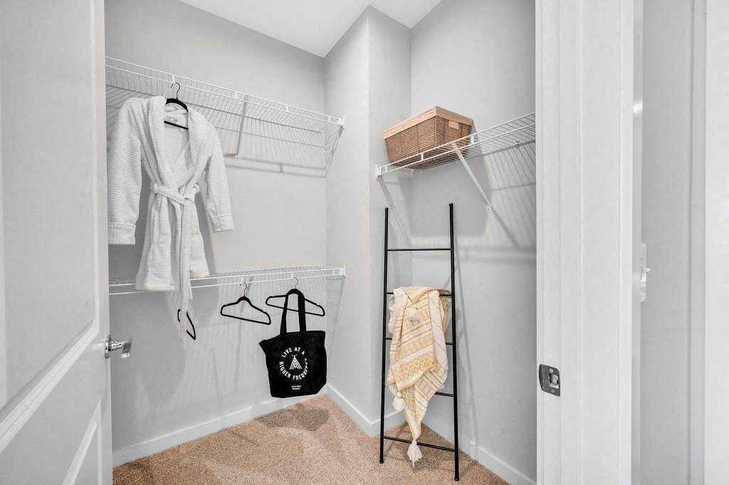 a closet with a rack and clothes hanging on the wall