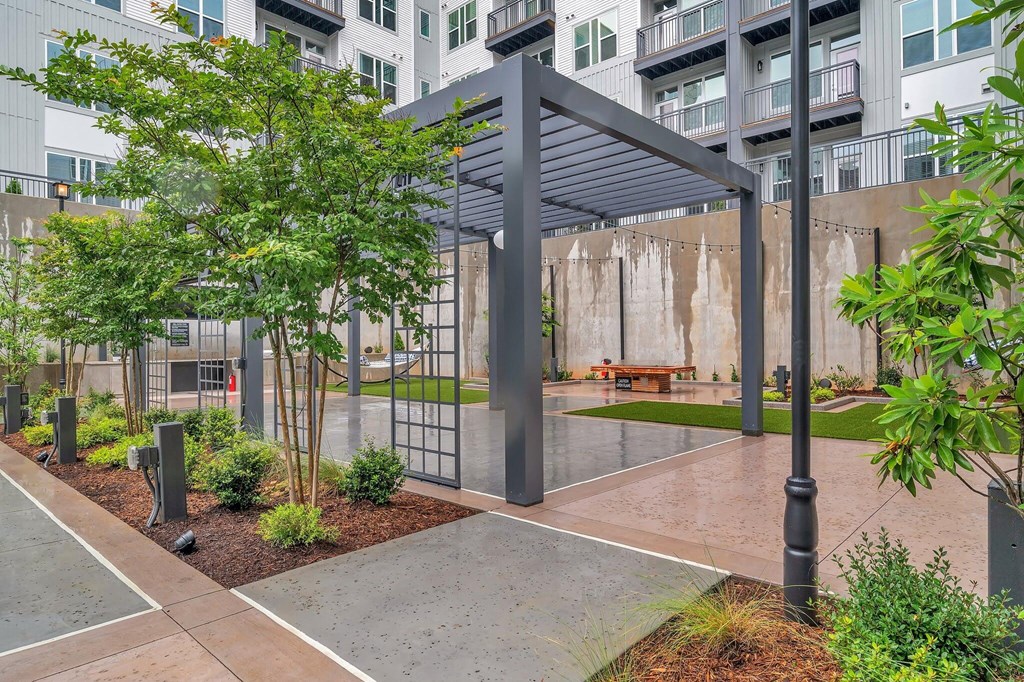 an outdoor courtyard with a bench and trees in front of an apartment building