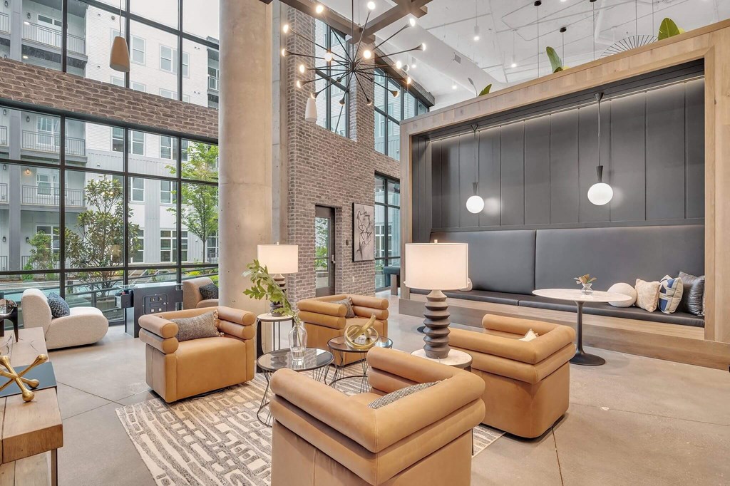 a lobby with couches and chairs and a large wall of windows