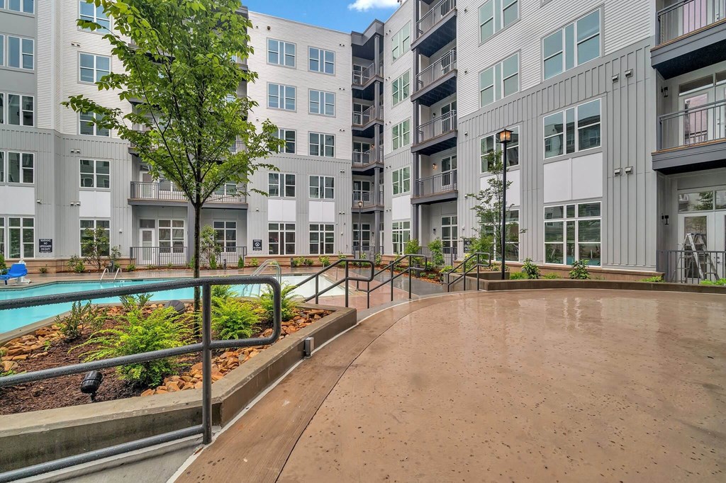 an empty courtyard with an apartment building and a pool