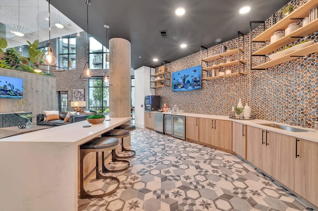 a kitchen with a long counter and stools in a lobby
