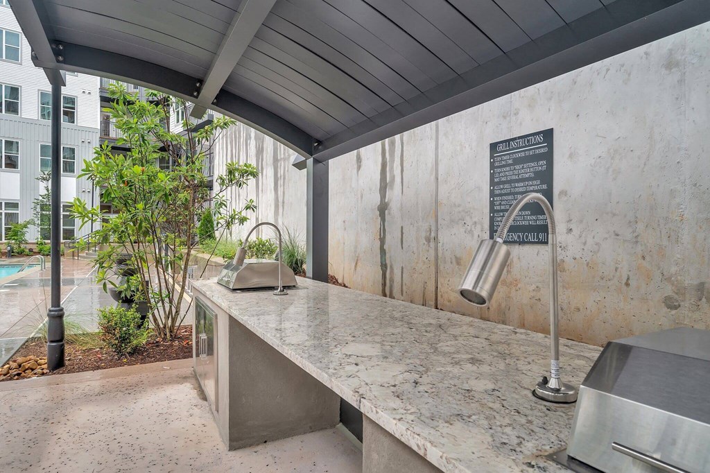 the kitchen has a concrete countertop and a sink with a large counter
