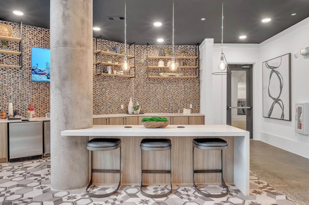 a tasting room with a long counter with black chairs