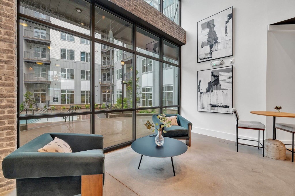a living room with large windows and a blue coffee table