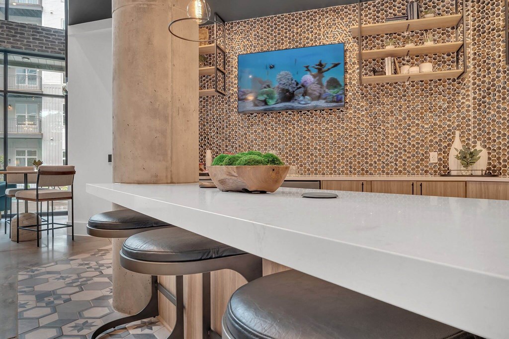 a kitchen with a long white counter and stools
