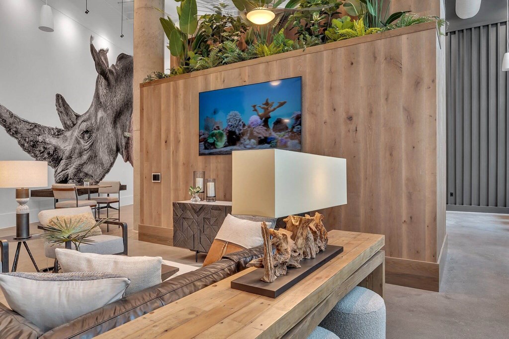 a living room with a wooden table and a giraffe on the wall