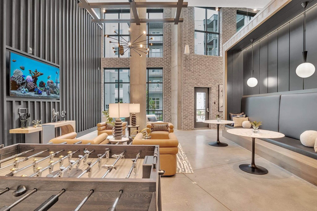 a lobby with couches and tables and a television